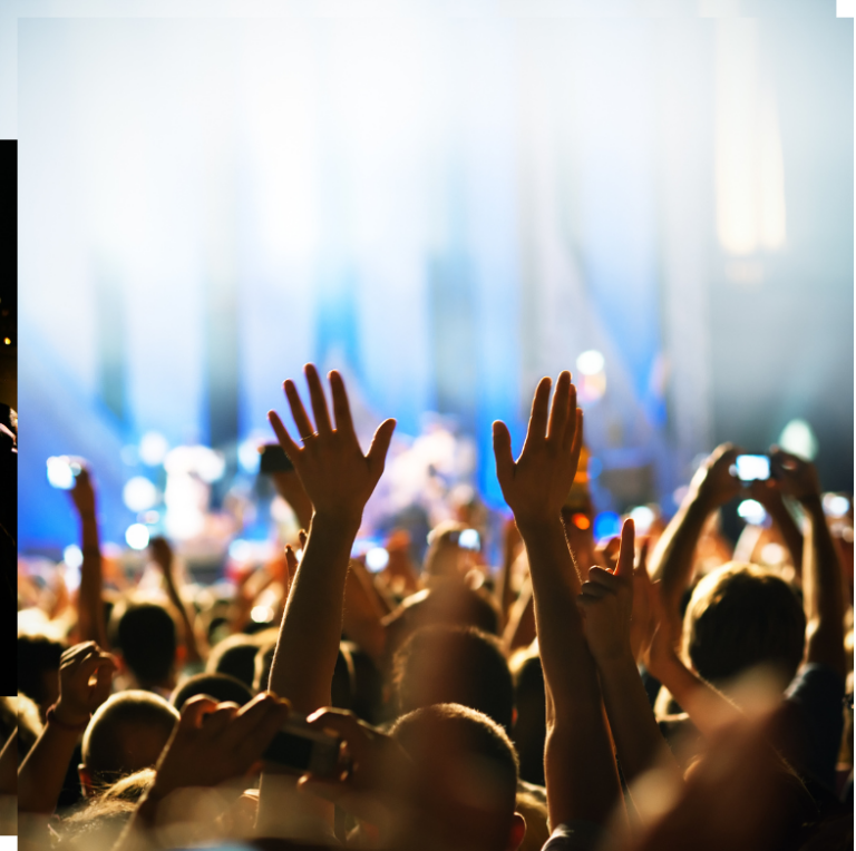 Concert crowd with raised hands reaching toward bright stage lights, representing healing and community.
