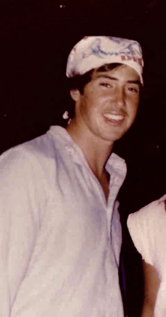 Jeffrey Berger smiling in a white shirt and one of the custom Grateful Dead bandanas he sold on tour.